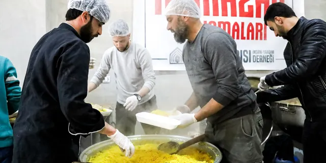 Suriye aşevimizde kazandan yemek paylaştıran gönüllülerimiz