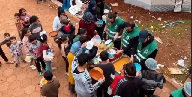 Sıcak yemek dağıtımında sıra bekleyen çocuklar ve aileler